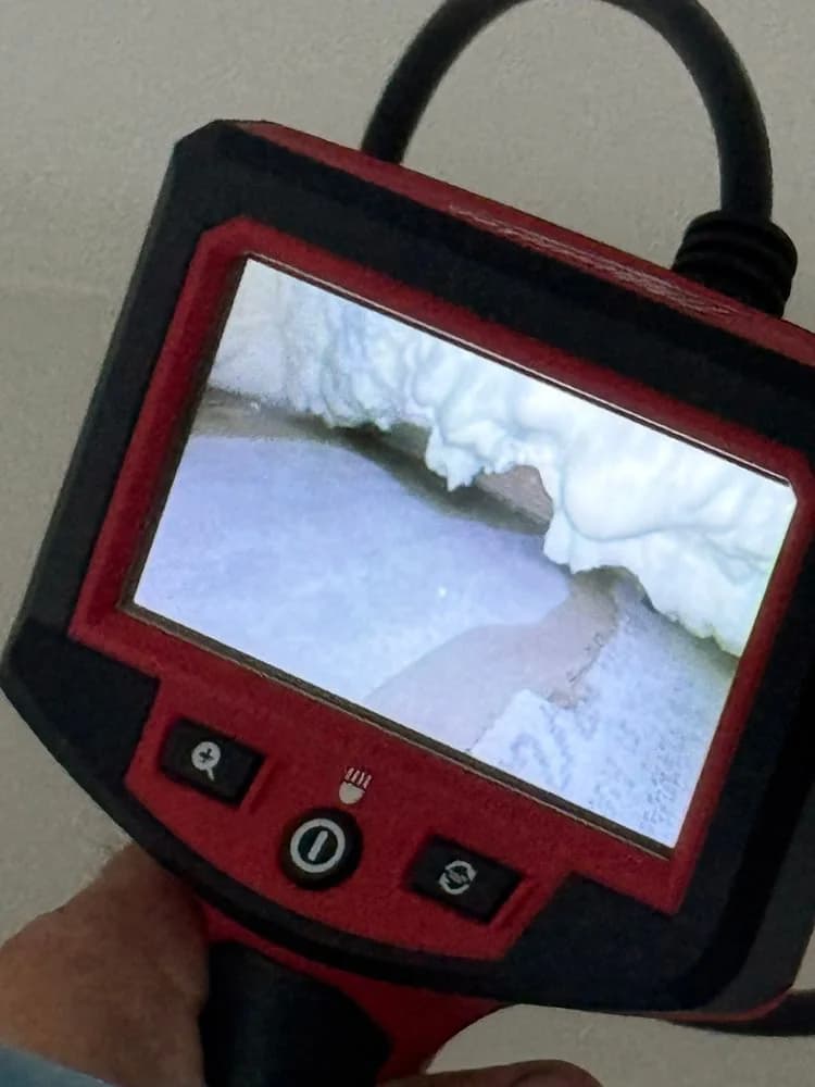 A borescope screen showing a water trail inside a wall cavity