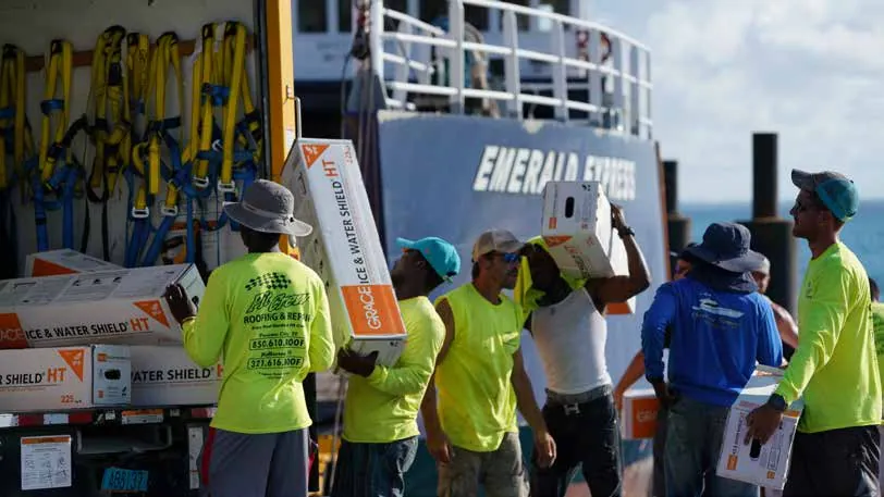 Crew unloading roofing underlayment from the supply ship Emerald Express