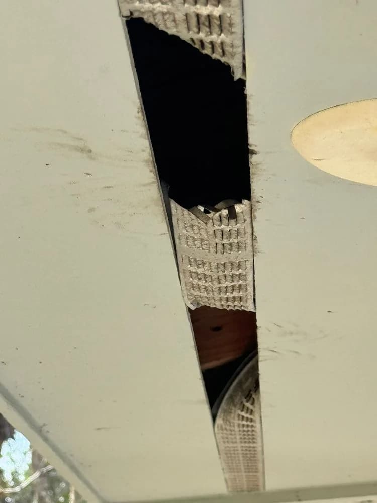 An opening in a soffit under the roof overhang