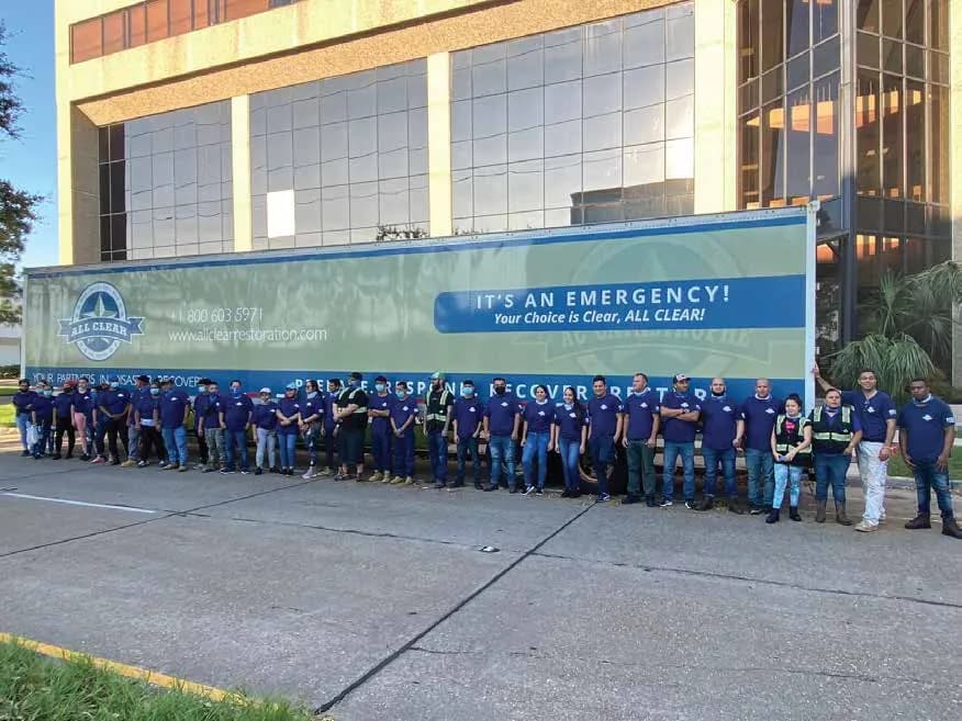 The ALL CLEAR team lined up in front of an ALL CLEAR emergency response trailer