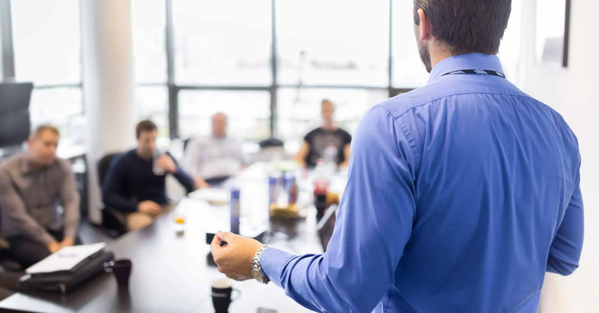 An instructor leading a training class around a conference table